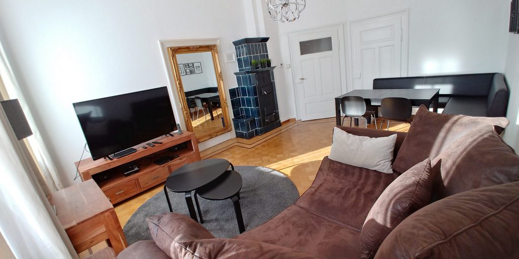 Apt-3_Wohnzimmer-Couch-Kamin-und-Stühle-1-scaled